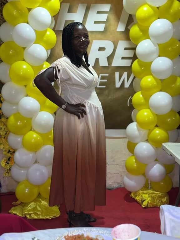 A woman posing beside a yellow and white balloon arch at Counselling 101