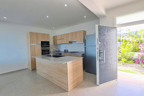 Open-plan kitchen with light-wood cabinetry and clean design, creating a bright and inviting culinary space.