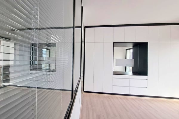 Glass wall room divider offering open spatial flow, transparency, and modern aesthetics within the home’s interior.