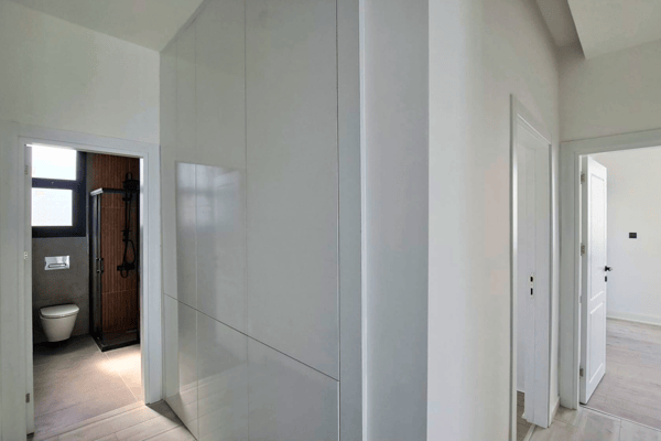 Narrow hallway adjacent to bedrooms with access to bathrooms.
