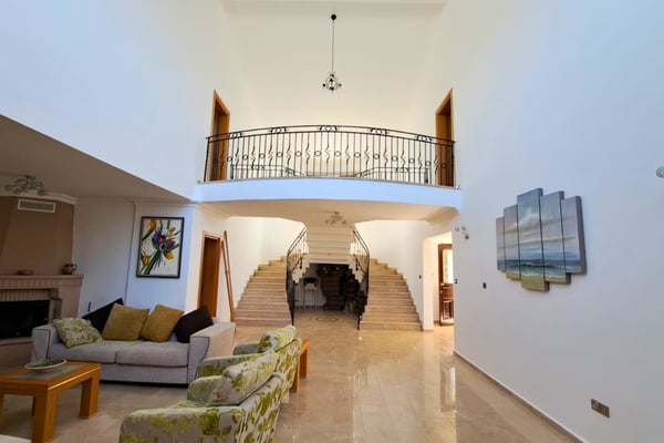 Grand marble entrance hall with clerestory window, arched alcove and gallery landing offering a refined welcome indoors.