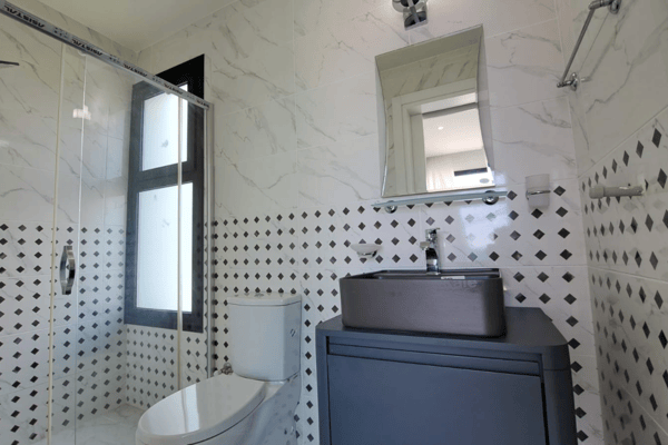 Modern bathroom with frosted glass details and sleek tiling that add to the villa’s refined atmosphere.
