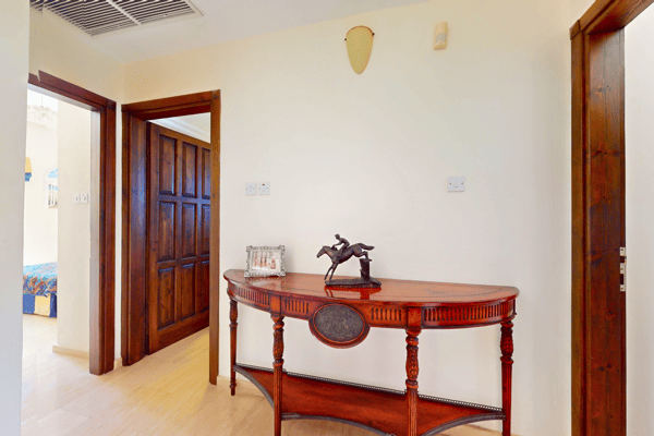 Console hallway with neutral decor and direct sight-lines to adjacent living areas.