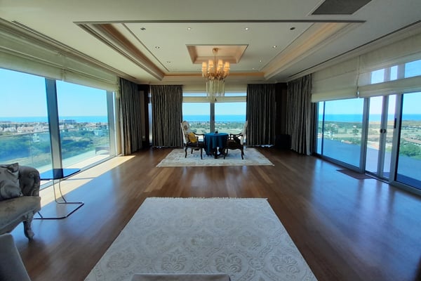 Cozy Bedroom with Fireplace and Large Windows – A stylish bedroom or sitting area featuring a spacious bed, tray or coffered ceiling, wood or tile flooring, and a cozy fireplace or mounted TV.