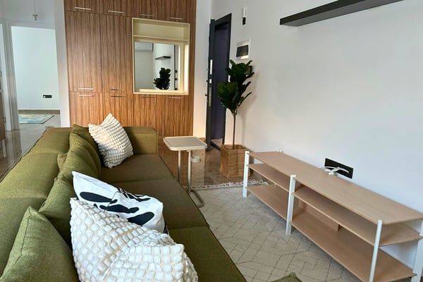 Alternate living area view with airy design, neutral furniture, and abundant daylight creating a welcoming and relaxed atmosphere.