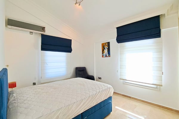 Guest bedroom with navy blinds and full wardrobe, styled for comfort and privacy with climate control included.