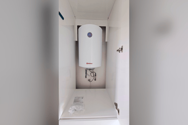 Utility space with water heater and built-in shelving.