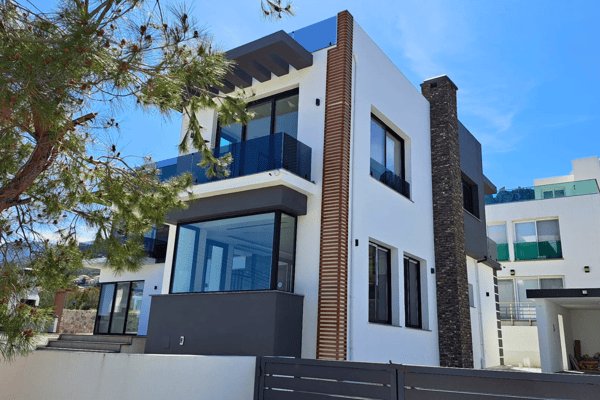 Elegant side perspective of a contemporary home surrounded by landscaped greenery, emphasizing serenity and upscale design.
