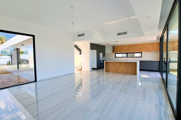 Open-concept kitchen with a central island, modern appliances, and elegant wood cabinetry blending into a sleek design.