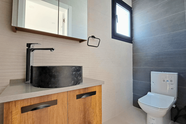 Shower area featuring dramatic dark tile-work and a luxurious rain shower head.