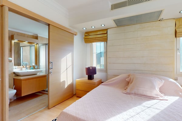 Another angle of the elegant bedroom featuring warm wooden accents, soft bedding, and artistic wall decorations for a cozy ambiance.