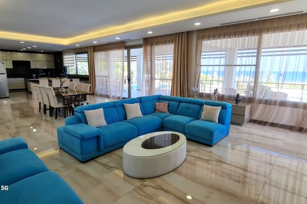 Serene bedroom in a luxury Esentepe villa, with an open balcony, crisp modern décor, and a breathtaking sea panorama.