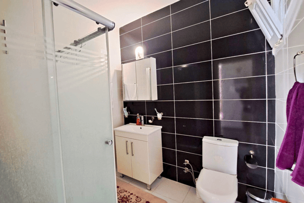 Boutique-style bathroom in dramatic black and white with modern fixtures, combining high-end design with everyday ease.
