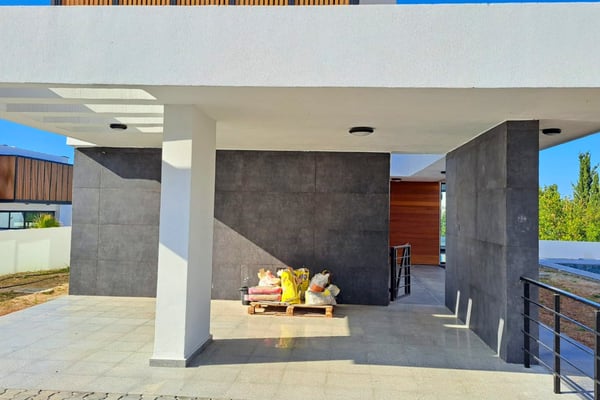 Covered outdoor terrace adjacent to the main living area, with tiled surfaces and clean modern finishes for shaded entertaining.