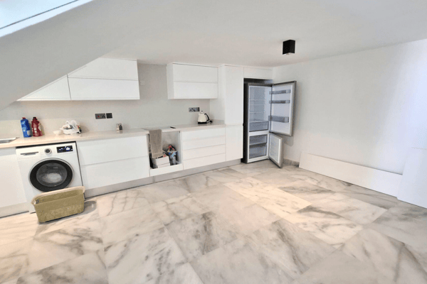 Laundry corner with washing machine and open-plan space.