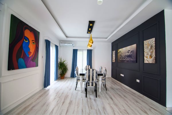 Designer dining room featuring elegant lighting, fine art, and stylish furnishings suited for refined hosting.