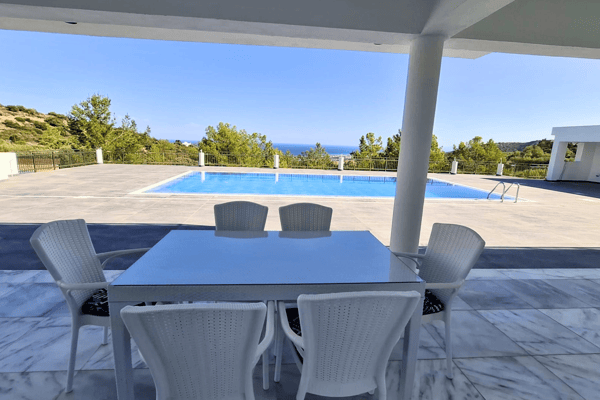 Patio seating area with white outdoor furniture, set under a canopy.