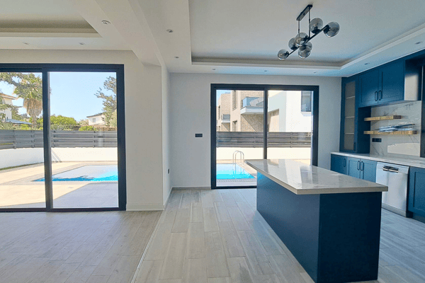 Full view of the kitchen and living area from poolside, with direct light and open layout.