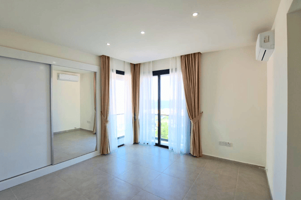 Spacious living room with neutral tones and recessed lighting, offering a calm and airy environment.