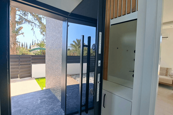 Side kitchen access with modern cabinetry and entry into main dining space.
