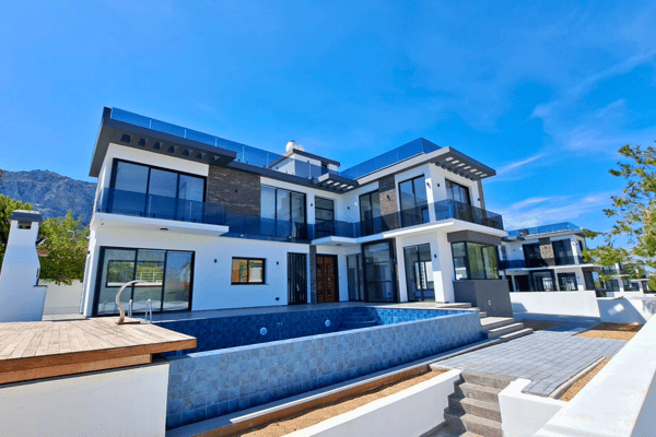 Alternate angle of the front, emphasizing the pool, sun deck, and full glass facade.