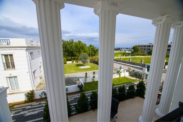 Architectural details include pillars and balconies with scenic views, blending style and natural beauty.