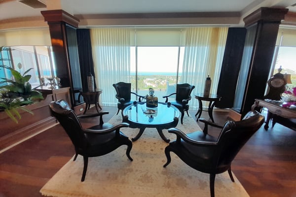 Luxury Home Office or Study with Built-In Shelving – A sophisticated study or lounge with built-in cabinetry, an elegant tray or coffered ceiling, and a combination of recessed and central lighting.