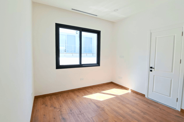 Bright guest or children’s bedroom with crisp finishes and large window.