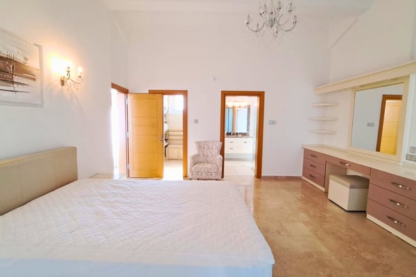 Fourth bedroom with bright French windows and twin beds, filled with morning light for a refreshing ambiance.