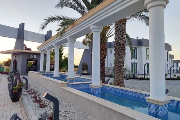 Side perspective of the complex with a private walkway and beautifully maintained greenery.