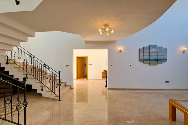 View of grand staircase with marble steps and iron railings, underscoring the home’s craftsmanship and classical tone.