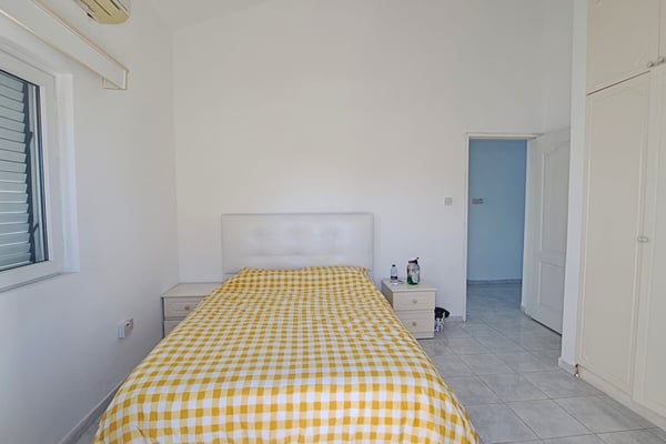 An alternate angle of the same bedroom, highlighting the furniture arrangement and natural lighting.