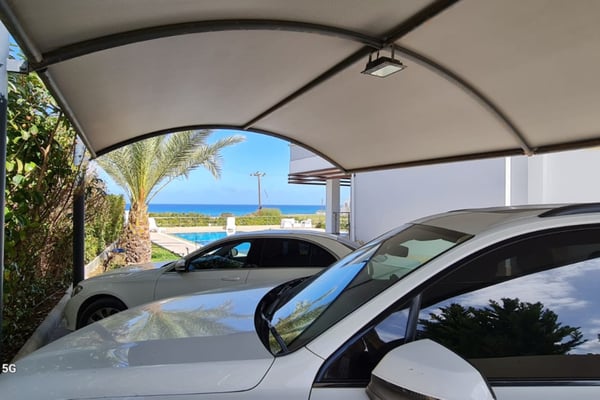 Living space in a high-end Esentepe villa, offering direct views of the infinity pool and Mediterranean coastline through sliding glass doors.