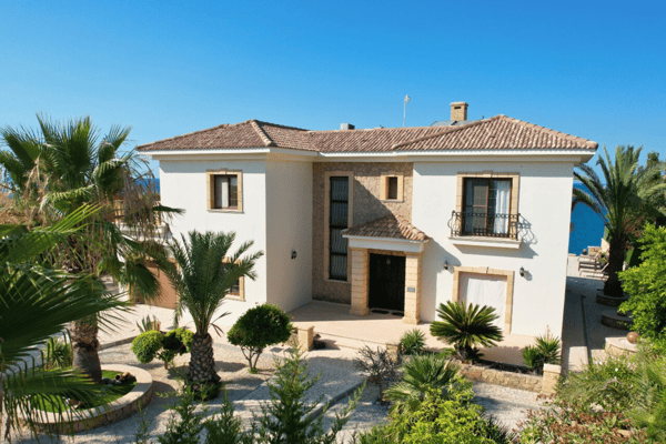 Frontal architectural view with large windows and neat landscaping, reflecting timeless Mediterranean design.