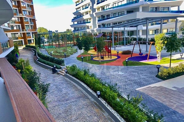 Lush green courtyard surrounded by peaceful pathways and blooming flowerbeds—an oasis of calm in the heart of the complex.