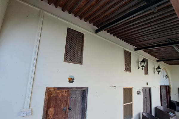 Hand-Carved Wooden Ceiling Beams – A ceiling with exposed wooden beams and rustic decor.