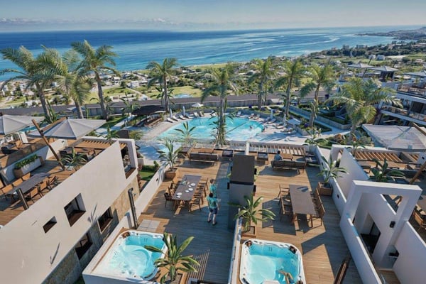 Modern multi-level building with rooftop spa deck, flat roofs, and expansive windows highlighting coastal architectural design.