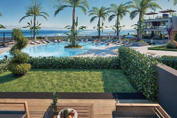 Scenic aerial showing the complex nestled between lush mountains and coastline, reflecting its picturesque surroundings.