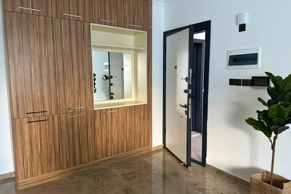 Bright hallway with polished flooring and stylish door design, emphasizing a secure yet inviting entrance to the home.
