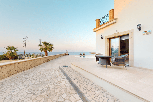 Driveway with sea view in background and clean garage access to the property.