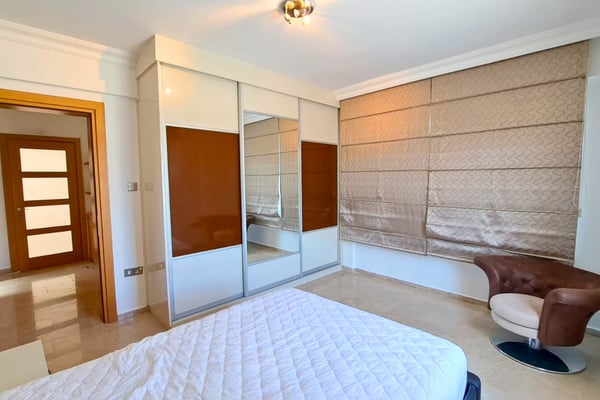 Extra bedroom with clean palette and panel headboard, adaptable as overflow guest space or staff accommodation.