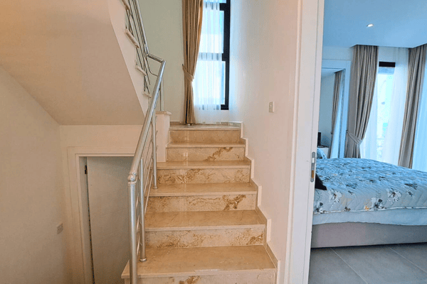 Ornate marble staircase with light floors that lead to upper levels, adding an elegant touch to the villa.