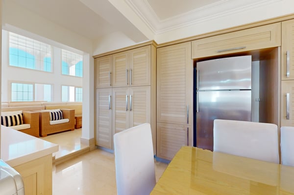 Large outdoor balcony with wooden flooring, seating arrangements, and a spectacular view of the surrounding greenery.