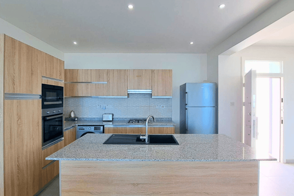 Alternate kitchen angle showing extended countertops and natural light that enhances the modern layout.