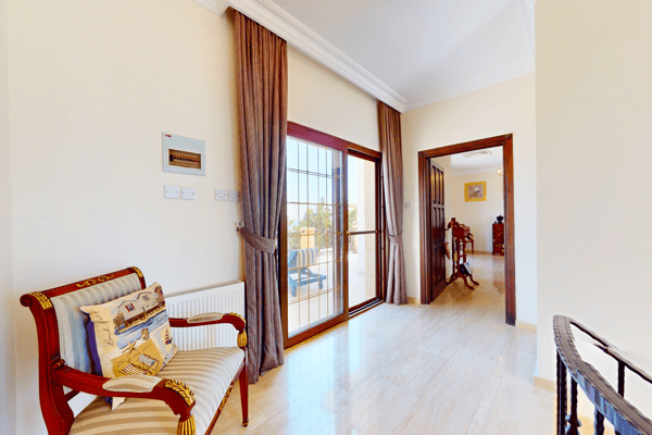 Sitting corner with armchair and access to a light-filled balcony—great for reading or relaxing.