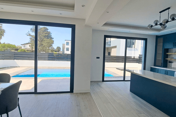 Bright living space with surrounding windows and direct outdoor access.