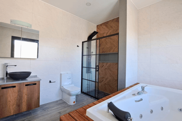 Main bathroom fitted with a built-in jacuzzi, tile finishes, and calming ambiance.
