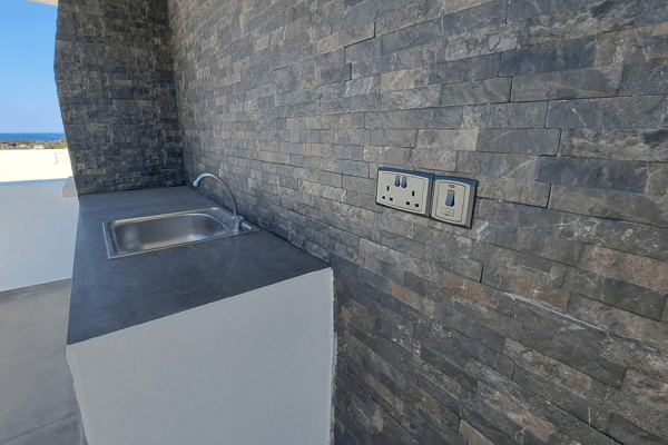 Close-up of the textured wall with electrical outlets for rooftop entertainment.