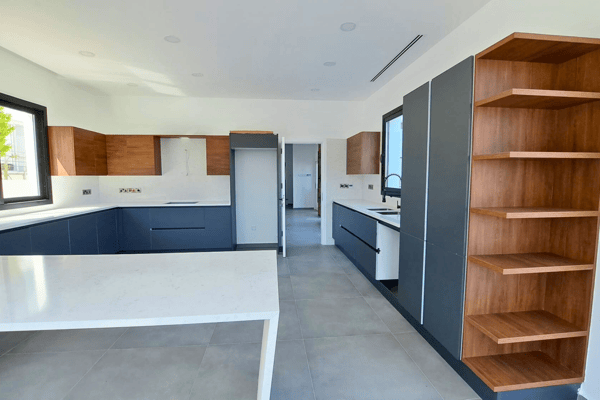 View into the main kitchen featuring warm wood tones and matte black cabinetry.