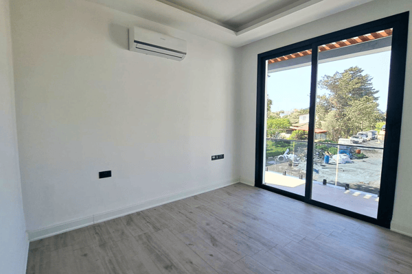 Rear bedroom with garden view and sliding doors.